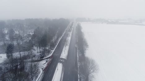 Aerial-View,-Dense-Fog-and-Light-Highway-Traffic-in-Snowy-Countryside-of-Germany-on-Gloomy-Winter-Day,-Drone-Shot