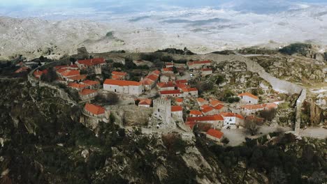 Sortelha-Remote-ancient-castle-on-arid-mountaintop,-Portugal,-aerial-dolly-out