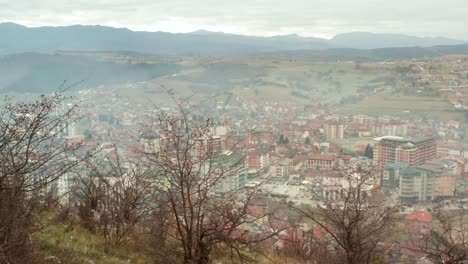 Tutin-town-in-Serbia-valley,-view-from-top-of-surrounding-mountains,-aerial-view