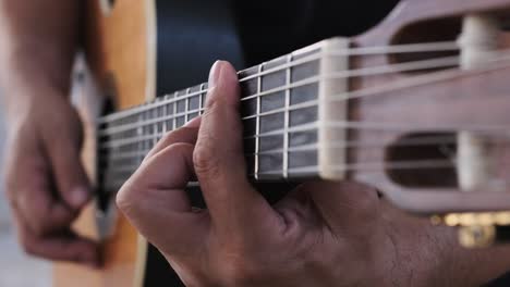 Playing-guitar,-unique-view-following-from-the-strumming-hand-to-fretting-hand-and-back-again