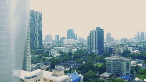 Vista-Del-Paisaje-Urbano-En-Bangkok,-Tailandia,-A-Través-De-Una-Ventana-De-Vidrio---Toma-De-Mano