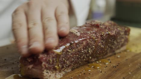 Adding-olive-oil-onto-meat-steak-on-the-cutting-board
