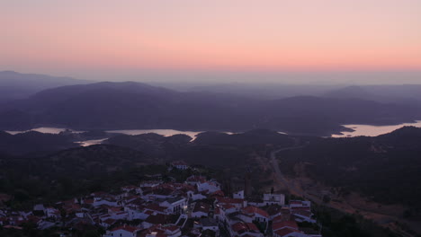 Beautiful-aerial-drone-shot-taken-above-a-Spanish-town-during-dawn,-showing-all-of-the-city-and-it's-beautiful-river-and-mountain-landscape,-Zufre,-Spain