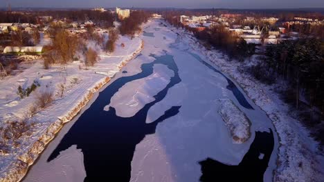 Bird's-eye-view-flying-over-a-the-frozen-river-of-Gauja-in-Latvia