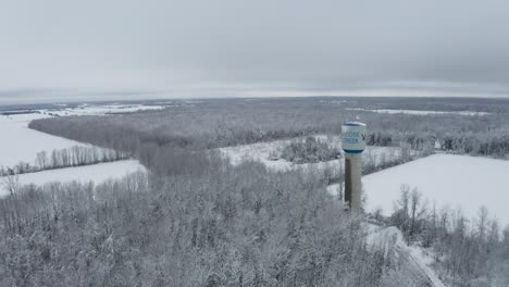 Moose-Creek-painted-on-water-tower-high-over-winter-wonderland-landscape-and-rural-farmland