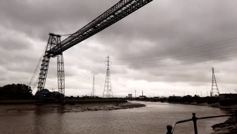 Time-lapse-shot-of-Newport-Transporter-Bridge-working-and-crossing-river-usk-during-dark-cloudscape-at-sky