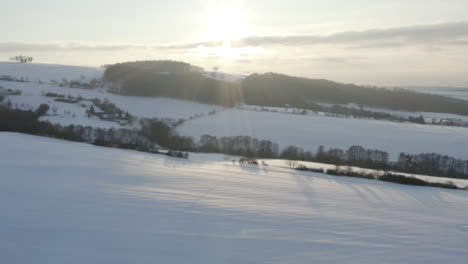 Toma-Aérea-De-Tierras-Agrícolas-Cubiertas-De-Nieve-Al-Amanecer,-Invierno-En-La-República-Checa-Rural