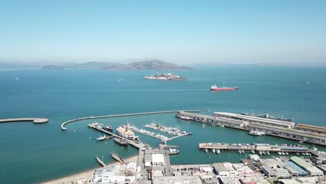 Antenne-Seitlich-Von-Fisherman&#39;s-Wharf-Bay-Und-Der-Insel-Alcatraz-An-Einem-Klaren-Tag-Mit-Einem-Vorbeifahrenden-Boot