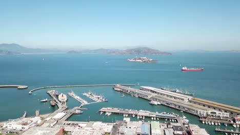 Aerial-sideways-of-Fisherman's-Wharf-bay-and-Alcatraz-island-on-a-clear-day-with-a-boat-passing