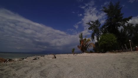Low-angle-timelapse-of-empty-sandy-beach-and-waving-palm-trees-on-Gili-Air-Island