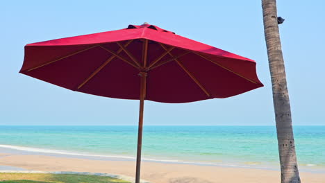 Red-Beach-Parasol-umbrella-on-blue-sky-and-sea-background