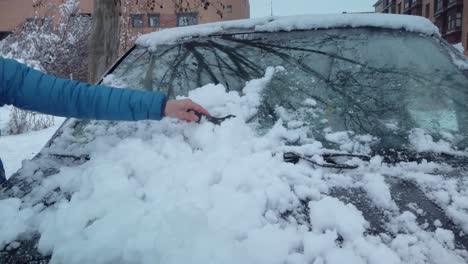 A-woman´s-arm-scratching-ice-from-a-windshield