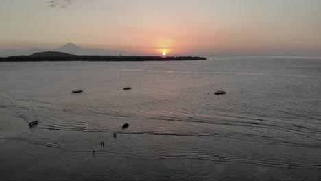 Timelapse-of-beautiful-romantic-sunset-with-ducks-in-swimming-in-ocean-on-Gili-Air-Island,Indonesia