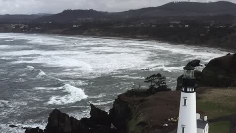 Aerial-view,-Yaquina-Lighthouse-over-North-Pacific-Ocean,-cloudy-overcast-afternoon