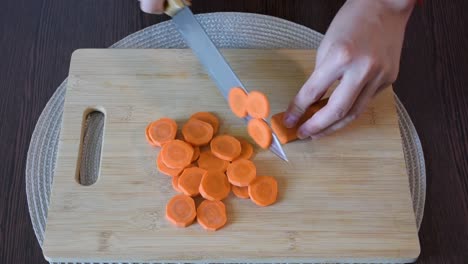 Woman's-hand-cutting-a-carrot.Top-view