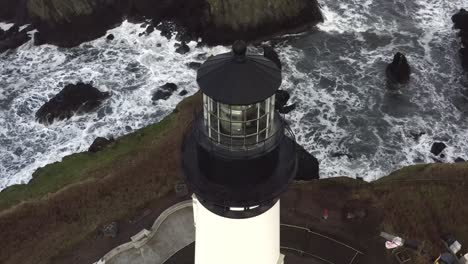 Cinematic-aerial-closeup,-Yaquina-Head-Lighthouse-overlooking-waves,-tourist-destination