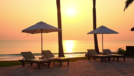 Sonnenschirm-Und-Liegestuhl-Leer-Am-Sandstrand-Mit-Meer-Im-Hintergrund-Bei-Sonnenuntergang