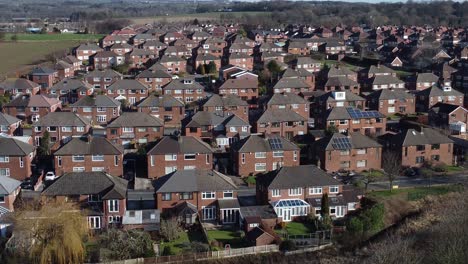 Aerial-view-above-typical-British-neighbourhood-homes-landscape-drone-property-community-slow-left-dolly-shot