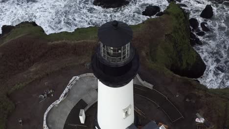 Amazing-aerial-view,-Yaquina-Head-Lighthouse,-tilt-up-orbit-around-island