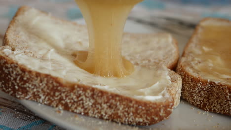 Breakfast-with-buttered-bread-slice-and-yellow-honey-spread-with-a-silver-knife