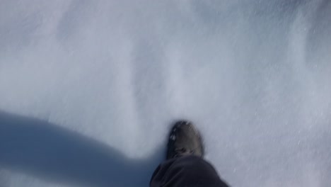Una-Toma-Fpv-De-Un-Par-De-Botas-Caminando-Sobre-La-Nieve