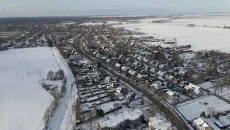 Aerial-of-small-rural-town-surrounded-by-snow-covered-meadows