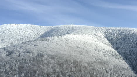 Cresta-Empinada-De-La-Montaña-Con-Bosques-En-La-Nieve-Del-Invierno,-Cielo-Soleado,-Chequia