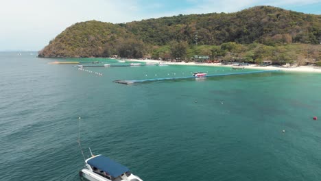 Crystal-clear-exotic-waters-of-Koh-Hey-with-floating-platform-dock,-in-Thailand---Aerial-Low-angle-Orbit-survey-shot