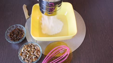 Making-cake-batter,-sifting-flour-to-make-it-more-airy