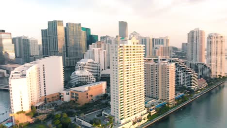Aerial-view-of-Downtown-Miami-urban-city-center-south-of-the-Miami-River-Brickell-at-sunrise,-panning-shot-to-the-left
