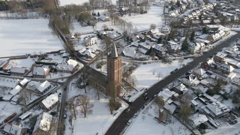 Aerial-orbit-of-church-in-snow-covered-rural-town