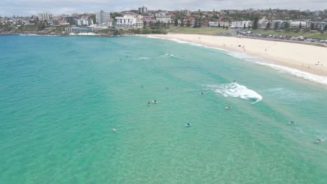 Surfers-Surfing-At-Bondi-Beach-By-Blue-Sea-In-Summer-In-Bondi,-NSW,-Australia