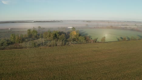 Morgennebel-Hüllt-Grüne-Felder-Ein,-Während-Die-Autobahn-Durch-Landwirtschaftliche-Flächen-Schneidet