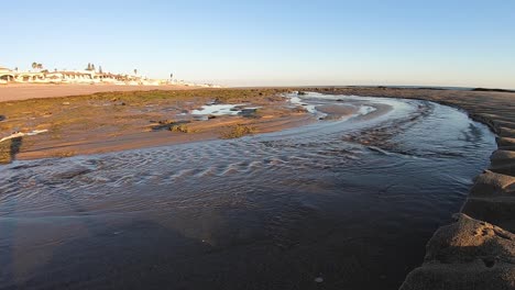 Low-tide-turns-seawater-into-a-flowing-river-from-the-beach-to-the-sea,-Gulf-of-California,-Rocky-Point,-Puerto-Peñasco,-Mexico
