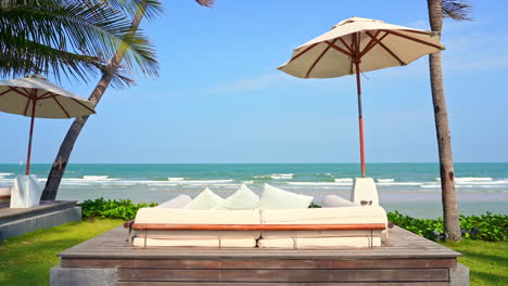 Luxus-Strandbetten-Und-Sonnenschirme-Mit-Herrlichem-Blick-Auf-Das-Tropische-Meer-Und-Die-Skyline-An-Sonnigen-Sommertagen-Mit-Leichter-Brise,-Vollbild