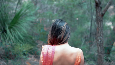Woman-Wearing-Red-Sari-Walks-Through-The-Forest---medium-shot