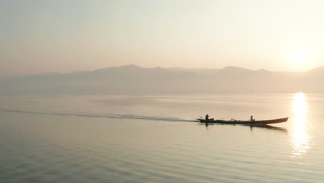 Dreamy-sunrise-over-Shan-Hills-with-boat-moving-on-surface-of-Inle-Lake