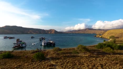 drone-fly-over-Gili-Lawa-Darat-in-Komodo-National-Park,-boat-cruise-park-in-the-bay,-unpolluted-dreamland-travel-touristic-destination-for-new-normal