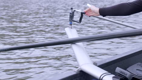 Close-up-clip-of-a-rower-unscrewing-and-attaching-their-oar-to-a-rigger,-outfoors-while-floating-on-the-Utrecht-canal-in-the-Netherlands