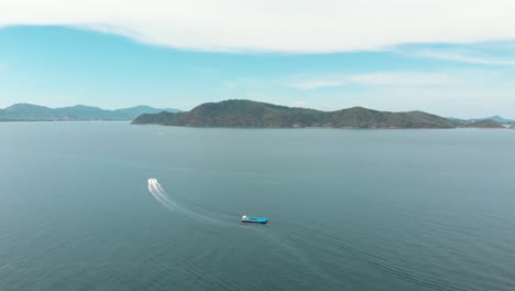 Speed-Boat-cruising-through-the-waters-between-Koh-Hey-and-mainland-Phuket,-Thailand---Aerial-wide-panoramic-shot
