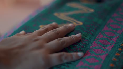 Mayan-woman-hand-touching-a-colorful-handmade-Guatemalan-Textile---slow-motion-close-up