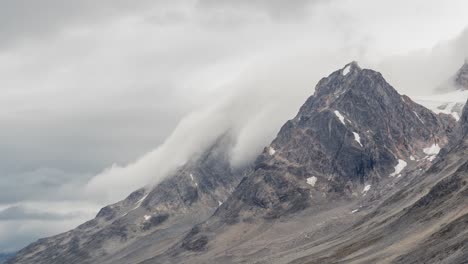 Wolken-Und-Nebel-Scheinen-Sich-über-Zerklüftete-Berggipfel-In-Grönland-Zu-Ergießen