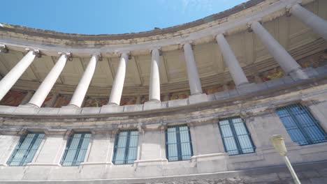 ángulo-Ascendente-Tiro-Giratorio-Lateral-De-Las-Columnas-Del-Monumento-Del-Cincuentenario-En-Bruselas,-Bélgica,-En-Un-Cálido-Día-Soleado-De-Verano-Con-Cielos-Azules