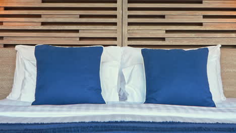 Luxusbett-Im-Schlafzimmer-Des-Exotischen-Tropischen-Resorts-Blaue-Und-Weiße-Kissen,-Nahaufnahme