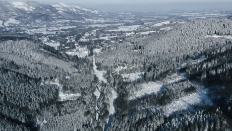 Toma-Aérea-De-Montañas-Y-Bosques-Cubiertos-De-Nieve,-Invierno-En-La-Hermosa-República-Checa