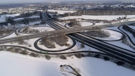 Snowy-Autobahn-or-Interstate-intersection,-aerial-drone-winter-view-on-sunny-day