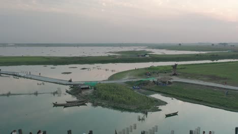 U-Bein-bridge-crossing-Taungthaman-Lake-in-Myanmar-during-sunset,-aerial