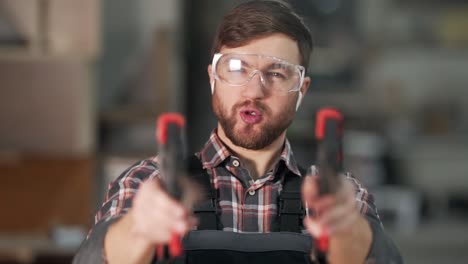 Close-up-portrait-of-a-worker-in-uniform-who-shoots-with-carpentry-clips