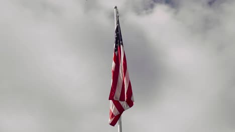 Amerikanische-Flagge-An-Der-Spitze-Eines-Fahnenmastes-An-Einem-Ruhigen-Bewölkten-Tag