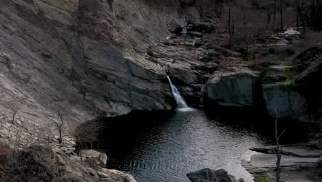 Tagsüber-Hoher-Drohnenflug-über-Wasser-In-Der-Nähe-Eines-Wasserfalls